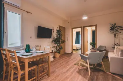 a living room with a table and chairs and a couch at Luxury Apartment with Acropolis view Terrace and Jacuzzi in the Heart of Athens - Living Stone Azurite in Athens
