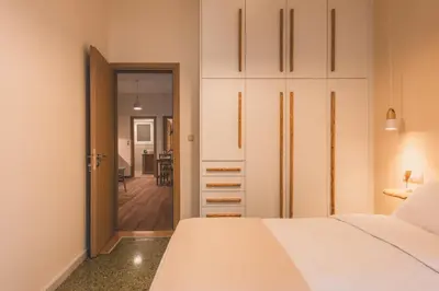 a bedroom with a white bed and a closet at Luxury Apartment with Acropolis view Terrace and Jacuzzi in the Heart of Athens - Living Stone Azurite in Athens