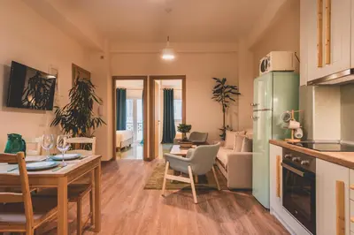 a kitchen and living room with a table and a couch at Luxury Apartment with Acropolis view Terrace and Jacuzzi in the Heart of Athens - Living Stone Azurite in Athens
