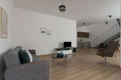 a living room with a couch and chairs and a staircase at Leochares Lifestyle Apartments - Self check-in in Athens