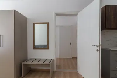 a white room with a bench and a mirror at Leochares Lifestyle Apartments - Self check-in in Athens