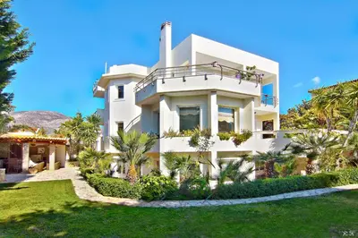 a white house with palm trees in front of it at In White Villa in Lagonissi