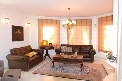a living room with a leather couch and a coffee table at In White Villa in Lagonissi