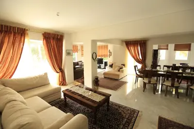 a living room with a couch and a dining room at In White Villa in Lagonissi