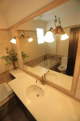 a bathroom with a sink and a large mirror at In White Villa in Lagonissi