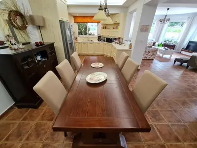 a dining room with a wooden table and chairs at In White Villa in Lagonissi