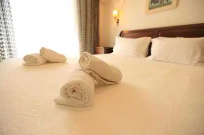 a towel on a bed in a hotel room at In White Villa in Lagonissi