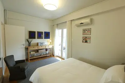 a bedroom with a bed and a chair and a window at Boutique17 Luxury Apartment 2nd floor in Athens