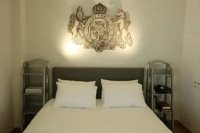 a bed with two pillows and a clock on the wall at Boutique17 Luxury Apartment 2nd floor in Athens