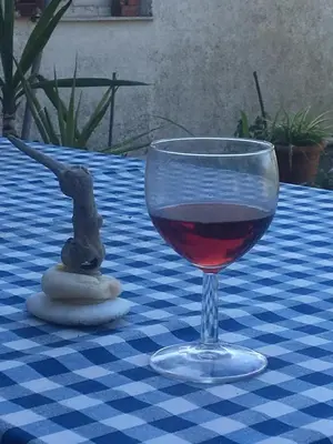a glass of wine sitting on a blue and white table at Kouklospito Cozy City Apartment in Kallithea Athens in Athens