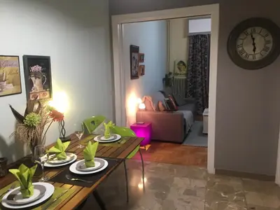 a living room with a table and a clock at Kouklospito Cozy City Apartment in Kallithea Athens in Athens
