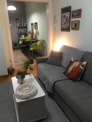 a living room with a gray couch and a table at Kouklospito Cozy City Apartment in Kallithea Athens in Athens