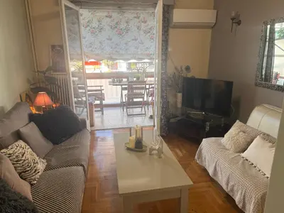 a living room with a couch and a table at Kouklospito Cozy City Apartment in Kallithea Athens in Athens