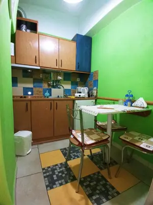 a kitchen with green walls and a table and chairs at Athens Neoclassical in Athens