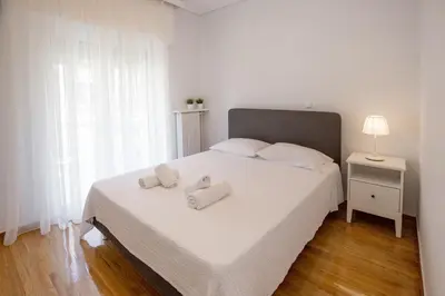 a bedroom with a white bed with two towels on it at Upscale Luxury Athens Renovated Dream Home in One of the most Favorable Locations by National Gardens, Zoo & Hellenic Parliament in Syntagma and Stylish Exquisite Kolonaki neighborhood in Athens