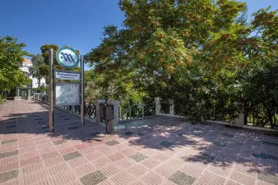 a sign on a brick sidewalk next to a tree at Upscale Luxury Athens Renovated Dream Home in One of the most Favorable Locations by National Gardens, Zoo & Hellenic Parliament in Syntagma and Stylish Exquisite Kolonaki neighborhood in Athens