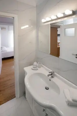 a white bathroom with a sink and a mirror at Upscale Luxury Athens Renovated Dream Home in One of the most Favorable Locations by National Gardens, Zoo & Hellenic Parliament in Syntagma and Stylish Exquisite Kolonaki neighborhood in Athens