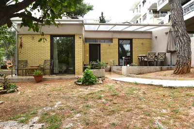 a yellow brick house with a yard in front of it at Amazing Garden House in Athens
