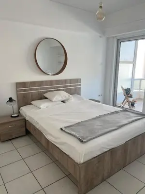a bedroom with a large bed and a mirror at Cute 1bd Apartment at Vouliagmeni in Athens