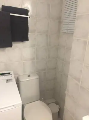 a white bathroom with a toilet and a sink at Cute 1bd Apartment at Vouliagmeni in Athens