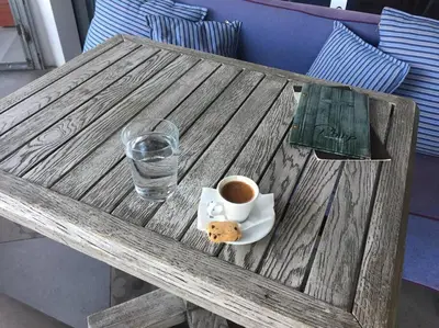 a wooden table with a cup of coffee and a cookie at Cute 1bd Apartment at Vouliagmeni in Athens