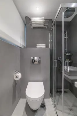 a bathroom with a white toilet and a shower at Momo Suites, Acropolis by Aura Homes in Athens