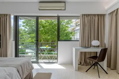 a bedroom with a bed and a desk and a window at Momo Suites, Acropolis by Aura Homes in Athens