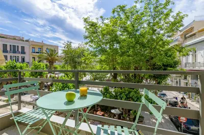 a table and chairs on a balcony with a tree at Momo Suites, Acropolis by Aura Homes in Athens