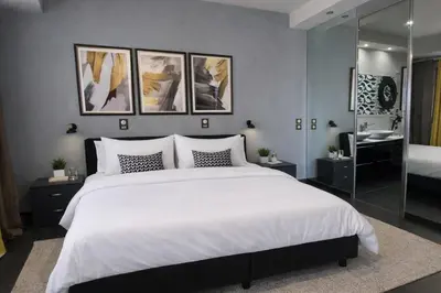 a bedroom with a large white bed and a mirror at 5-Star feel - Luxury penthouse for 4 with huge balcony & view ,8 min from Athens airport in Koropíon