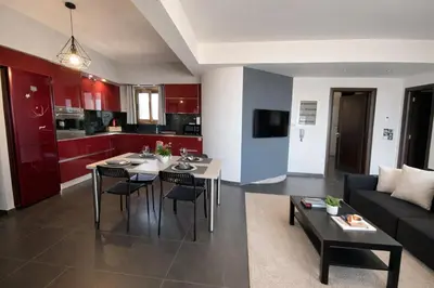 a living room with a table and a couch at 5-Star feel - Luxury penthouse for 4 with huge balcony & view ,8 min from Athens airport in Koropíon