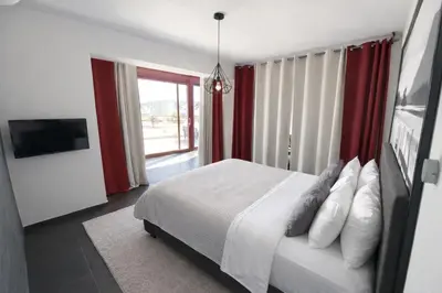 a bedroom with a bed and a large window at 5-Star feel - Luxury penthouse for 4 with huge balcony & view ,8 min from Athens airport in Koropíon