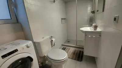 a bathroom with a toilet and a sink and a washing machine at METROPOLITAN MACVIEW-4 ΔΙΑΜΕΡΙΣΜΑ in Piraeus