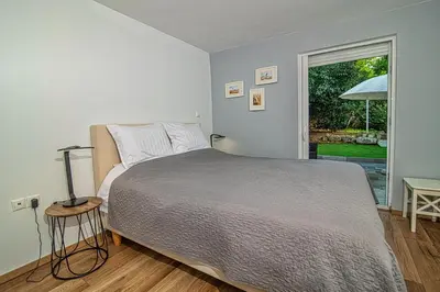 a bedroom with a large bed and a window at LIVAS Athens Voula garden bungalow in Athens