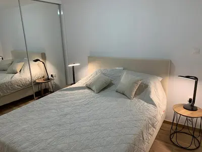 a bedroom with a large white bed with two lamps at LIVAS Athens Voula garden bungalow in Athens