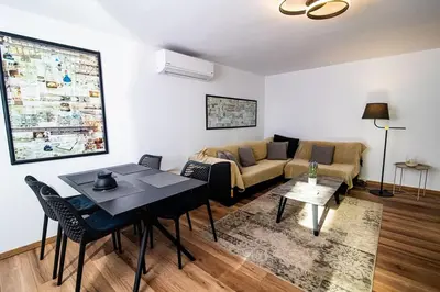 a living room with a couch and a table at LIVAS Athens Voula garden bungalow in Athens