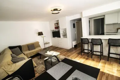a living room with a couch and a kitchen with a counter at LIVAS Athens Voula garden bungalow in Athens