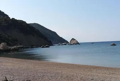 a beach with some rocks in the water at LIVAS Athens Voula garden bungalow in Athens