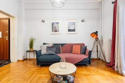 a living room with a couch and a table at Downtown Cute Apt in the Heart of Plaka (+Netflix) in Athens