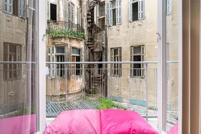 a pink umbrella sitting outside of a window at Downtown Cute Apt in the Heart of Plaka (+Netflix) in Athens