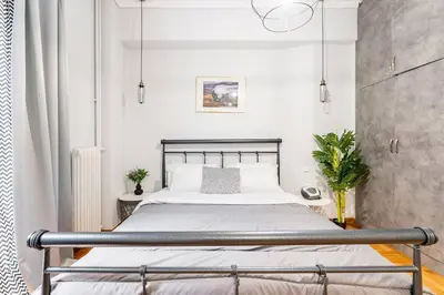 a bedroom with a bed in a white room at Downtown Cute Apt in the Heart of Plaka (+Netflix) in Athens