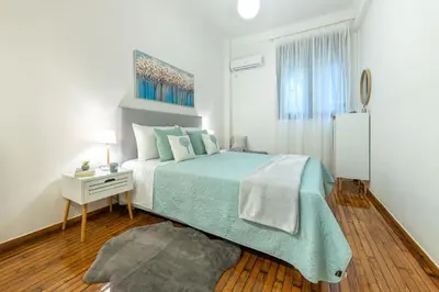 a white bedroom with a bed and a nightstand with a bed sidx sidx sidx at Nadia’s Boutique Apartment, Athens in Athens