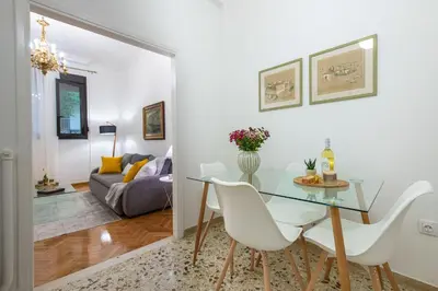 a dining room with a glass table and white chairs at Nadia’s Boutique Apartment, Athens in Athens