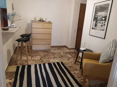 a living room with two chairs and a dresser at Maria's Cozy apartment in Palaio Faliro in Athens