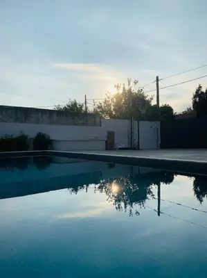 a swimming pool with the reflection of the sun in the water at Astra House in Porto Rafti