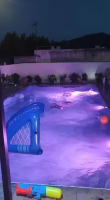 a swimming pool at night with purple lights at Astra House in Porto Rafti