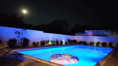 a large swimming pool at night with a swimming pool at Astra House in Porto Rafti