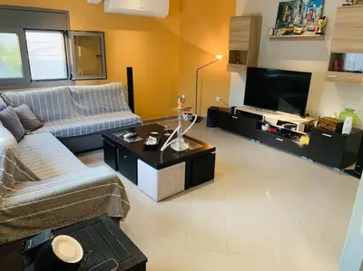 a living room with a couch and a tv at Astra House in Porto Rafti