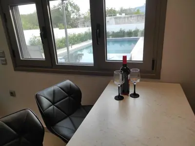 a table with two glasses and a bottle of wine at Astra House in Porto Rafti
