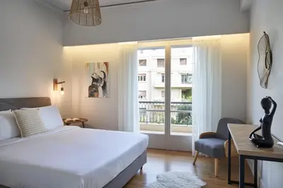 a bedroom with a bed and a desk and a window at Chic n Bright 3Bd Apt with Hilton View in Athens