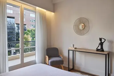a bedroom with a bed and a chair and a window at Chic n Bright 3Bd Apt with Hilton View in Athens